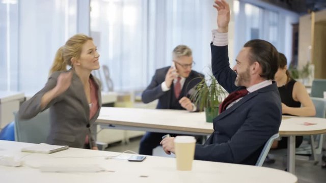  Excitable corporate business team competing with each other in modern office
