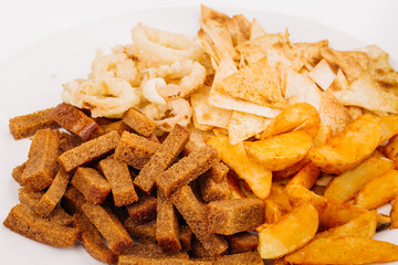 Fast food snacks composition with onion rings,  crackers, baked potatoes, chips, toast.