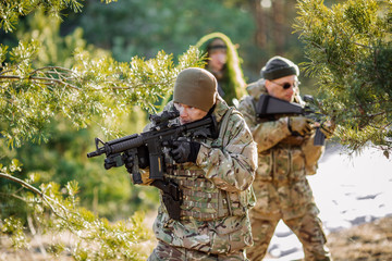 Fototapeta premium team of special forces weapons in cold forest. Winter warfare and military concept