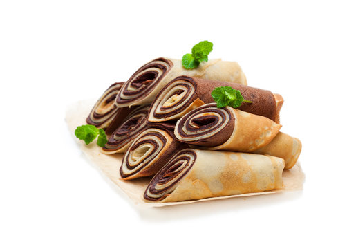 Rolled  milk and chocolate pancakes isolated on white