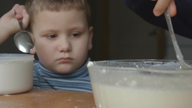 caucasian Boys prepare the dough and the younger looks at the dough