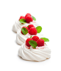 Mini  Pavlova meringue nests with berries and mint on isolated on white