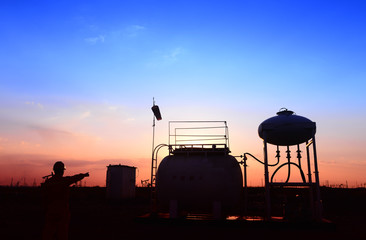 Fototapeta premium The oil tank, under the background of the setting sun