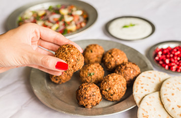 Woman with beautiful hands eating falafel. Healthy food, fitness, and sport diet concept.