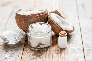 fresh coconut with cosmetic oil in jar on wooden background