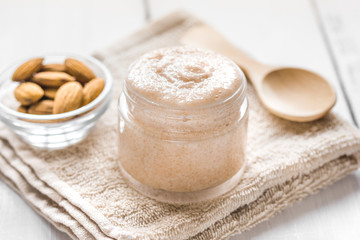 cosmetic for women with almond scrub on desk background