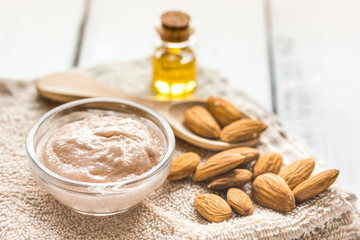 cosmetic set with almond scrub on table background