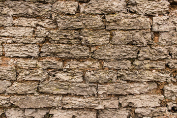 Old weathered fortified wall of limestone.