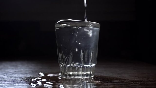 Poured glass of vodka, spreads on the table