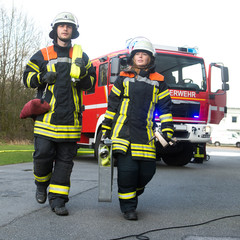 Naklejka premium Feuerwehrmann und Feuerwehrfrau an einer Einsatzstelle