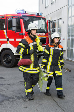 Feuerwehrmann und Feuerwehrfrau an einer Einsatzstelle