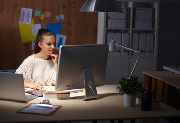 Young woman working in office, sitting at desk