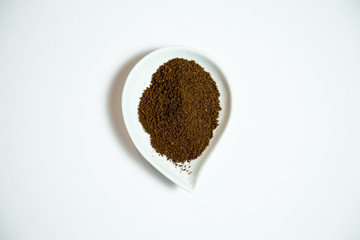 Ground Puerto Rican coffee in a white teardrop tray