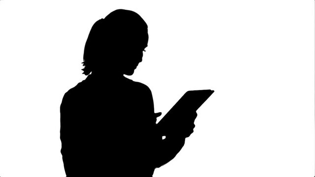 Silhouette Concentrated businesswoman standing with digital tablet.