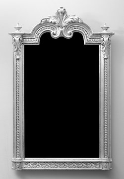 Beautiful antique wooden mirror frame mounted on the wall in black and white