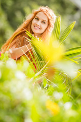 Obraz na płótnie Canvas outdoor portrait of young happy smiling woman on natural tropical background