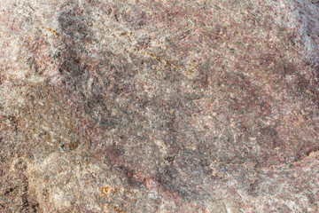 Texture of an uneven surface of a stone, a rock in natural natural conditions, a close-up background