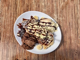 Waffle with chocolate,  vanilla ice-cream and banana from top view