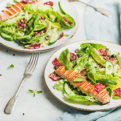 Healthy energy boosting spring salad with grilled salmon, blood orange, olives and quinoa over grey marble background, selective focus, square crop. Clean eating, dieting, detox, weight loss concept