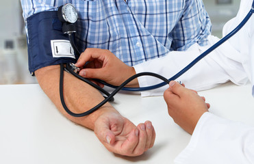 Doctor measuring blood pressure with sphygmomanometer
