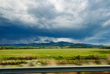 View of storm over the mountains in distance