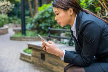 Fototapeta premium woman sitting and using smart phone