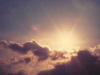 Fototapeta premium Abstract blurry nature background of sun behind grey clouds with soft style, vintage filter effect