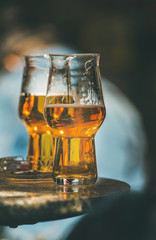 Two glasses of beer on a table in a street cafe, selective focus, vertical composition