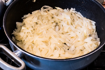 Onions are frying in pan.
