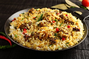 Homemade delicious mutton dum biriyani or pilaf served in cast iron cookware.