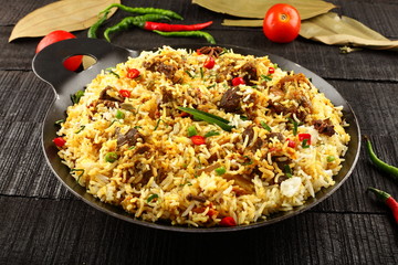 Homemade delicious mutton dum biriyani or pilaf served in cast iron cookware. © susansam90