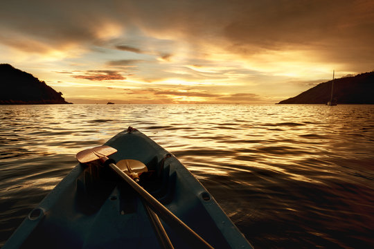 Kayak bow at sunset sea backdrop