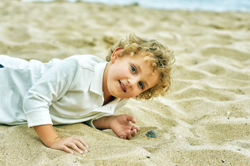 little boy playing on the sea shore . The concept of children's leisure