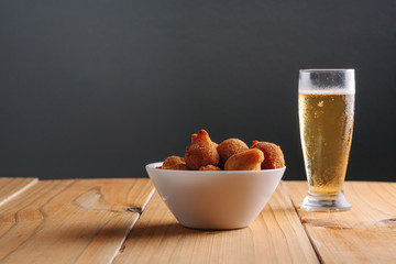 Brazilian snack "coxinha" and beer on wood table