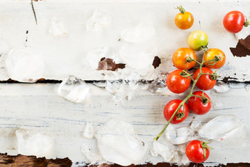 Naklejka na ściany i meble red cherry tomatoes on white table background. 