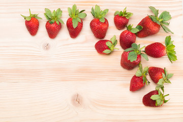 strawberry lies in the corner on a light wooden table