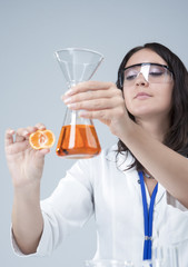 Medicine and Research Ideas. Laboratory Female Staff Dealing with Apple Specimen and Test Liquid in Flask.