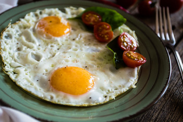Scrambled eggs with tomatoes on wooden background