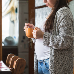 A young pregnant woman holding a cup, close-up - 143118792