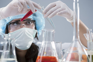 Scientific Research Concept and Ideas.Female Laboratory Staff Conducting Experiment with Two Luquid Specimens in Flasks In Laboratory.