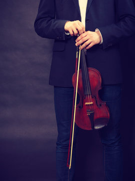 Man man dressed elegantly holding violin