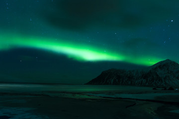 Fototapeta na wymiar Aurora Borealis Known as Nother Lights Playing with Vivid Colors Over Lofoten Islands in Norway.
