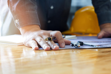 Architect holding a pen on project blueprint, architectural concept