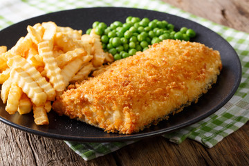 Fish and chips with green peas close-up on a plate. horizontal