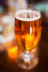 Beer in beer glass with very shallow depth of field and only part of foam in focus