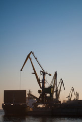 Fototapeta na wymiar cargo cranes and cargo ship in the Industrial port. 