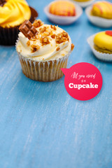 Cupcakes with buttercream and macaroons. Almond macaron cookies. Sweet dessert cakes. On wooden table.