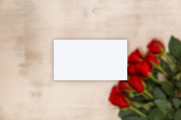 Business card mockup. Red roses on wood vintage background. Concept for romantic love design. Fresh natural flowers.
