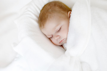 Cute little newborn baby girl sleeping wrapped in blanket