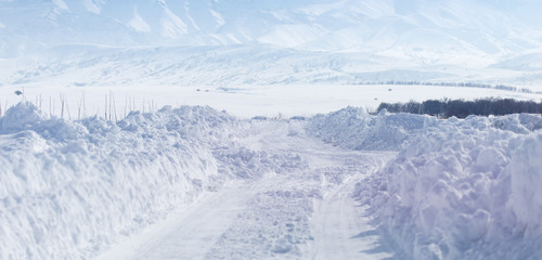 Fototapeta na wymiar Road in the snow in the foothills